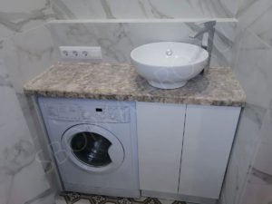 стиральная машина в ванной под столешницей из камня